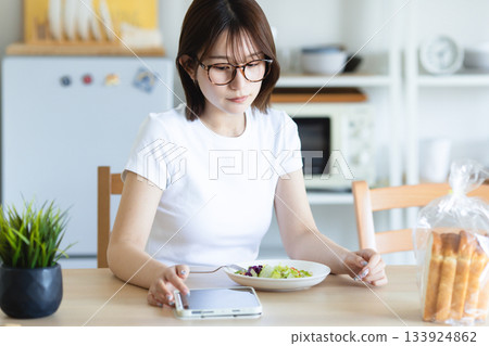 A young woman eating breakfast A young woman eating breakfast 133924862