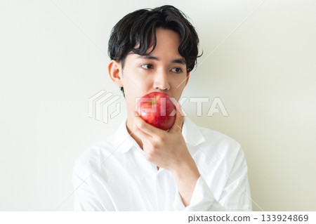 Young man holding an apple 133924869
