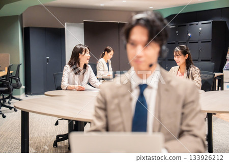 Women working and talking happily in the office Women working and talking happily in the office 133926212