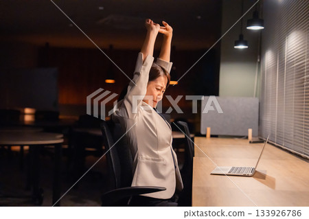 一位女經理在辦公室加班到天黑，已經筋疲力盡。 133926786