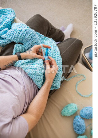 Modern hipster man crochet handmade hobby use hook knitting needles and wool yarn top view closeup 133926797