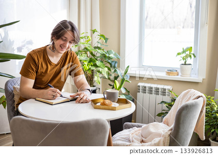 Stylish confident guy writing in journal 133926813