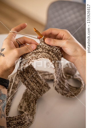 Man hands crochets handmade crocheting supplies assorted wool yarn hook knitting top view closeup Man hands crochets handmade crocheting supplies assorted wool yarn hook knitting top view closeup 133926817