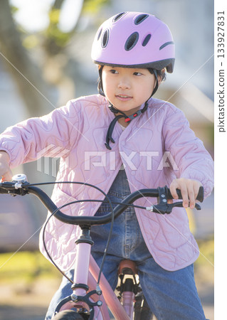 一名亞洲兒童在公園練習騎自行車，在戶外安靜地玩耍。 133927831