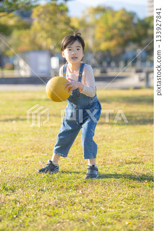 Girl holding a ball in the park Girl holding a ball in the park 133927841