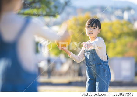 Cheerful girl playing dodgeball in the park Cheerful girl playing dodgeball in the park 133927845