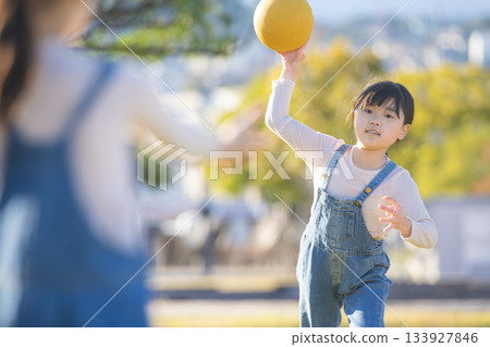 一個活潑的女孩在公園裡玩躲避球時丟球的那一刻 133927846