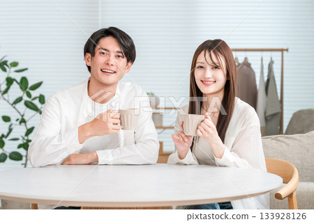 坐在家客廳餐桌旁的年輕亞洲夫婦(未來規劃、生活計畫、生活方式) 坐在家客廳餐桌旁的年輕亞洲夫婦(未來規劃、生活計畫、生活方式) 133928126