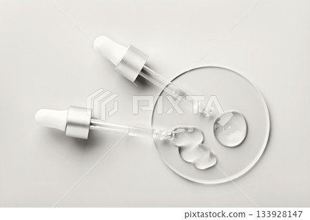 Two droppers applying clear hyaluronic acid gel. Color of the Year concept 133928147