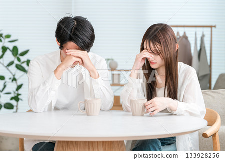 Worried, troubled, depressed young Asian couple at the dining table 133928256
