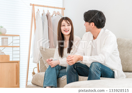 Young Asian couple sitting on sofa in living room at home 133928515