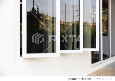 Three panel aluminium casement window stay on white wall. 133929022