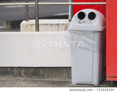 自動販賣機旁邊放置了一個用於丟棄空罐子的垃圾桶。 133929194