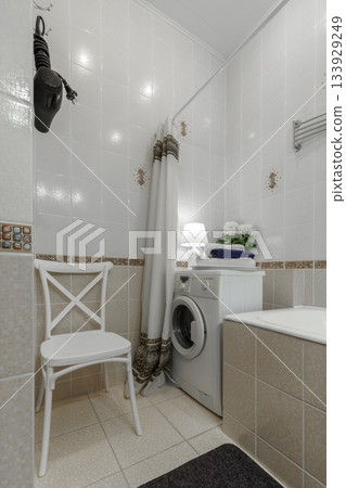 Small Cozy Bathroom Interior with Washing Machine and Chair Small Cozy Bathroom Interior with Washing Machine and Chair 133929249