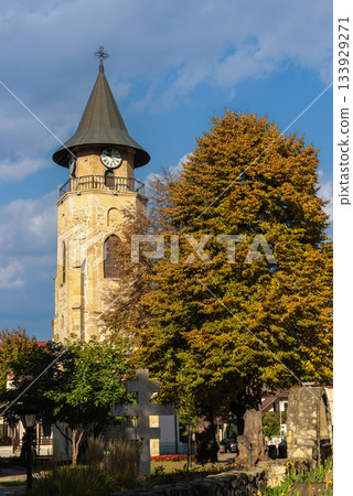 Medieval clock tower framed by autumn trees Piatra Neamt Romania Medieval clock tower framed by autumn trees Piatra Neamt Romania 133929271