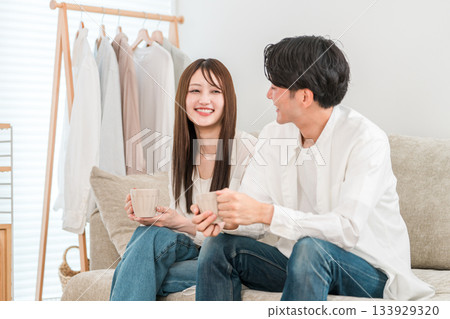 Young couple relaxing on the sofa with a hot drink 133929320