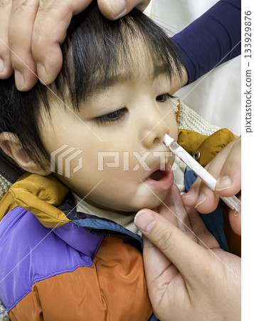 A 2-year-old boy receiving a Flumist flu vaccination A 2-year-old boy receiving a Flumist flu vaccination 133929876