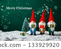 Gnomes wearing red long hat holding gift box standing on snowy  ground with a small Christmas tree on snow falling green background. 133929920