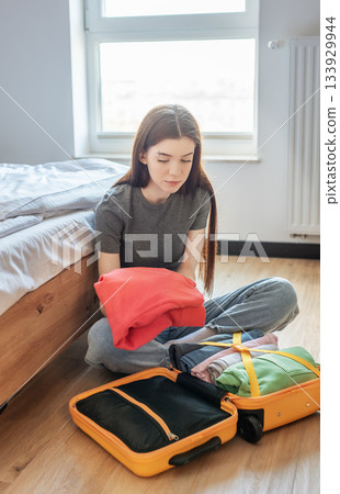 Woman packing suitcase with clothes for vacation travel Woman packing suitcase with clothes for vacation travel 133929944
