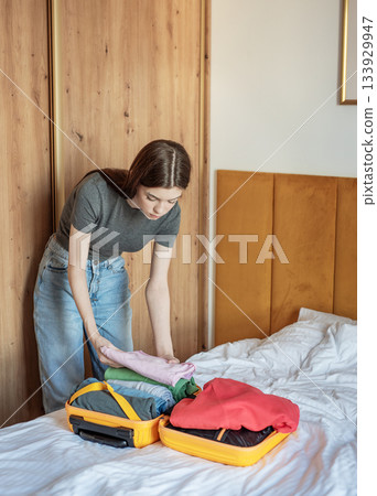 Young woman packing clothes for an upcoming trip 133929947