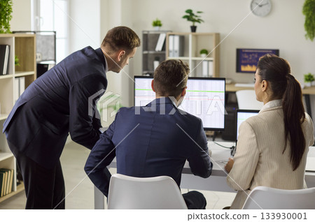 Business team reviewing spreadsheets on monitors during office workflow planning Business team reviewing spreadsheets on monitors during office workflow planning 133930001