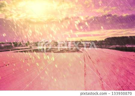 Rural landscape in winter during snowfall. Winter in the countryside. Snowy field at sunset with dramatic cloudy sky Rural landscape in winter during snowfall. Winter in the countryside. Snowy field at sunset with dramatic cloudy sky 133930870