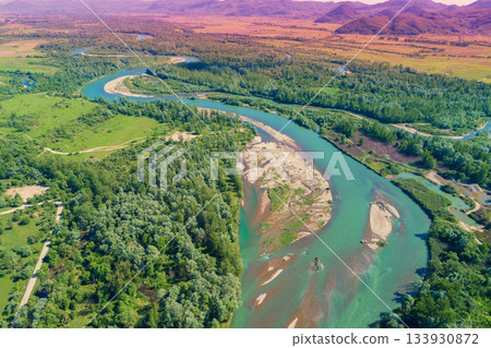 Winding river in the valley on a sunny day. Panoramic view from above of mountain valley. Nature landscape. Tisza river, Zakarpattia Oblast, Ukraine Winding river in the valley on a sunny day. Panoramic view from above of mountain valley. Nature landscape. Tisza river, Zakarpattia Oblast, Ukraine 133930872