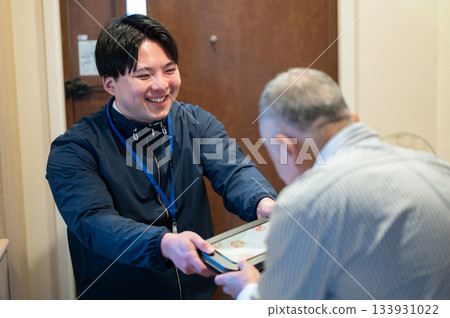 Delivery person handing over a home-cooked lunch Delivery person handing over a home-cooked lunch 133931022