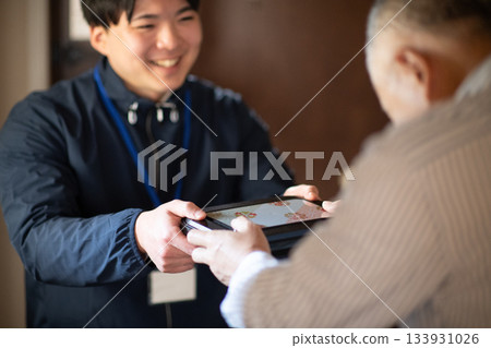 Delivery person handing over a home-cooked lunch 133931026