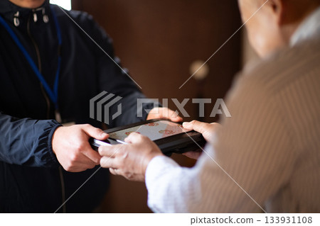 An elderly man receiving a home-delivered lunch box An elderly man receiving a home-delivered lunch box 133931108