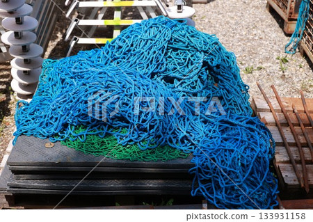 A pile of blue and green fishing netting A pile of blue and green fishing netting 133931158