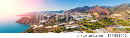 Panoramic view of the sea of greenhouses. Greenhouses in the south of Spain near Maro city, Nerja, Malaga, Spain. View from a drone. Horizontal banner 133931222