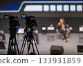 Cameras on tripods at a live panel discussion in a modern studio setting 133931859