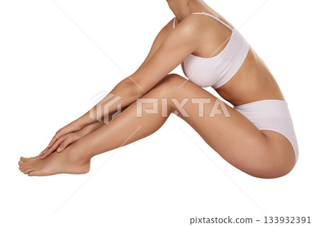 Seated female figure showcasing toned limbs, isolated on white, PNG Seated female figure showcasing toned limbs, isolated on white, PNG 133932391