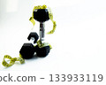 Black dumbbells are artistically arranged with yellow measuring tape on a bright white background, representing fitness, health, and wellness concepts for active lifestyles 133933119
