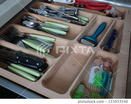 Cutlery on wooden shelf in kitchen. Storage, organization. Clean cabinets and shelves. Knives, spoons and forks, small items for everyday use. Cutlery on wooden shelf in kitchen. Storage, organization. Clean cabinets and shelves. Knives, spoons and forks, small items for everyday use. 133933540