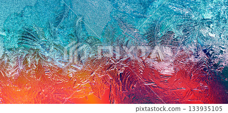 Photo of a frozen window with a colorful background outside the window. Natural texture of ice on glass. Colorful abstract nature background. Horizontal banner 133935105