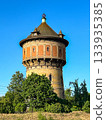 A stunningly beautiful historic water tower stands majestically amidst lush greenery under a clear blue sky 133935385