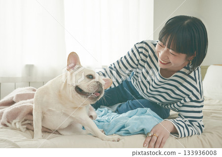 狗和女人在床上放鬆 133936008