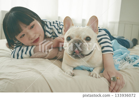 Dog and woman lying on bed Dog and woman lying on bed 133936072