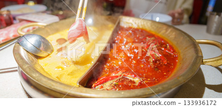 Woman tourist eating traditional hot pot or mala spicy soup in restaurant. Popular foods for tourist eating in Chengdu, Chongqing and China. Chinese Asia and Sichuan foods concept 133936172