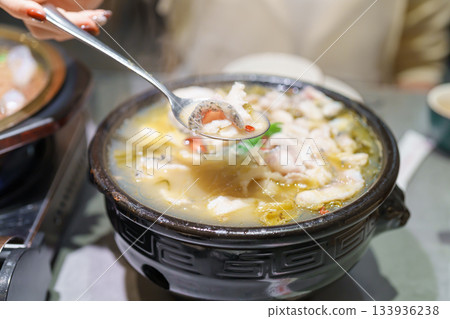 Woman tourist eating Sichuan Fish with Pickled Mustard Greens or Suan Cai Yu in restaurant. Popular foods for tourist eating in Chengdu, Chongqing and China. Chinese Asia and Sichuan foods concept 133936238