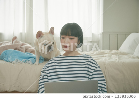 一位女士正在用電腦，她的寵物也在旁邊。 133936306