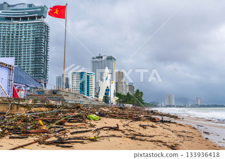 Piles of garbage and waste on beach by sea after a storm in cloudy rainy weather. Environmental disaster on coast of Nha Trang resort city in Vietnam Piles of garbage and waste on beach by sea after a storm in cloudy rainy weather. Environmental disaster on coast of Nha Trang resort city in Vietnam 133936418