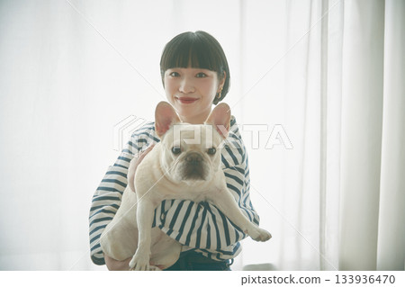 窗邊，女子抱著狗 133936470
