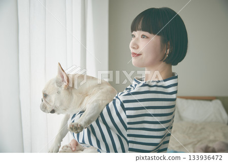 窗邊，女子抱著狗 133936472