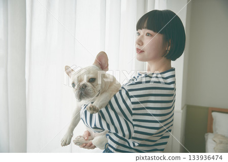 窗邊，女子抱著狗 133936474