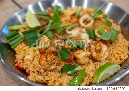 Seafood Tom yum fried rice, a dish of rice  with tom yum paste, garlic and chili fried with prawn, squid and mussel, served on a pan 133936591