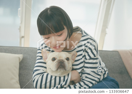 Dog and woman relaxing on sofa 133936647