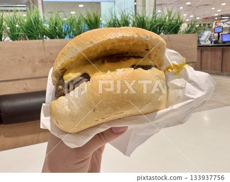 Russian hamburger with fresh bread and juicy fried patty with sauce in hand Russian hamburger with fresh bread and juicy fried patty with sauce in hand 133937756